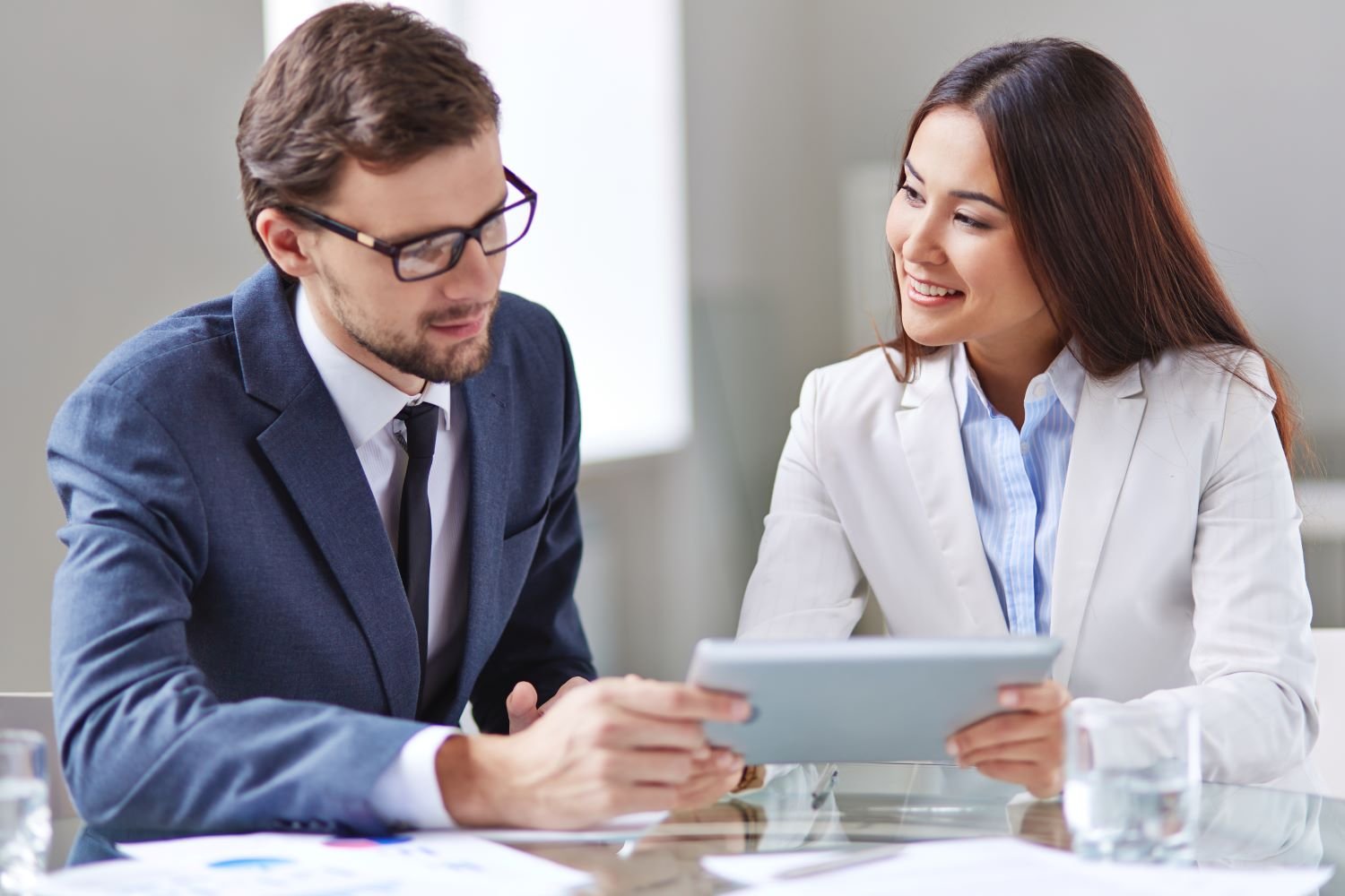 A person sitting and working with paperwork and more.