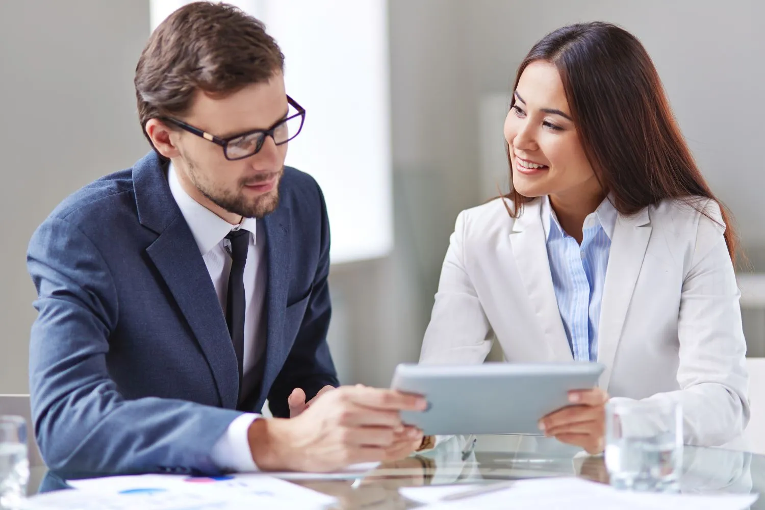 A person sitting and working with paperwork and more.