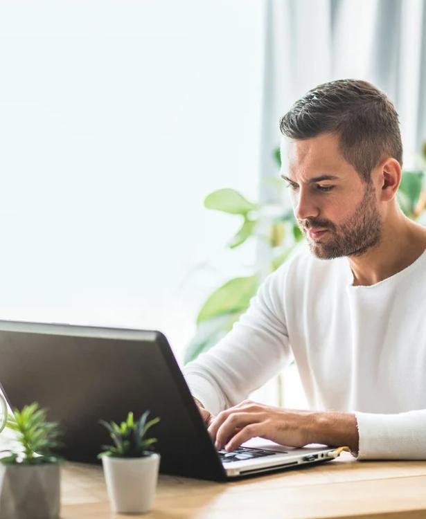 A person typing on their computer in their house.